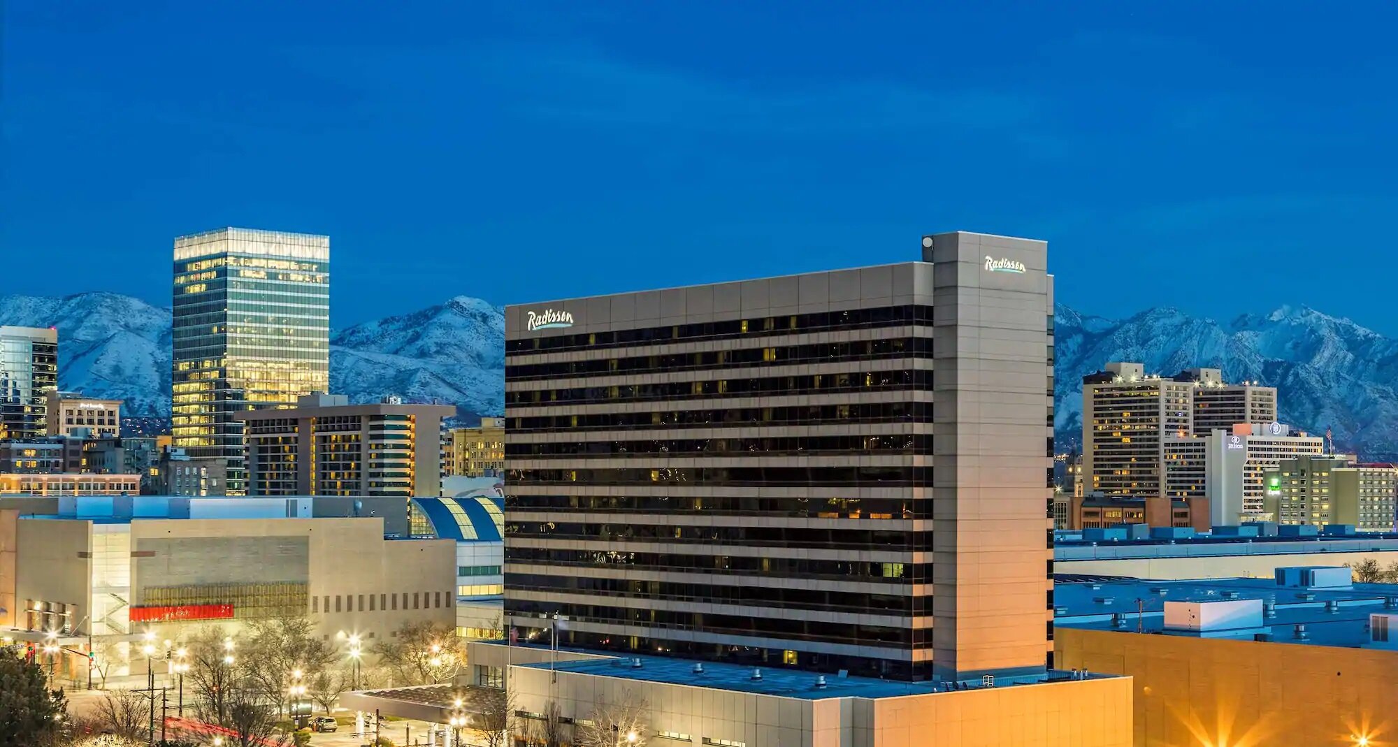 Photo of Radisson Hotel against the Salt Lake City skyline at dusk